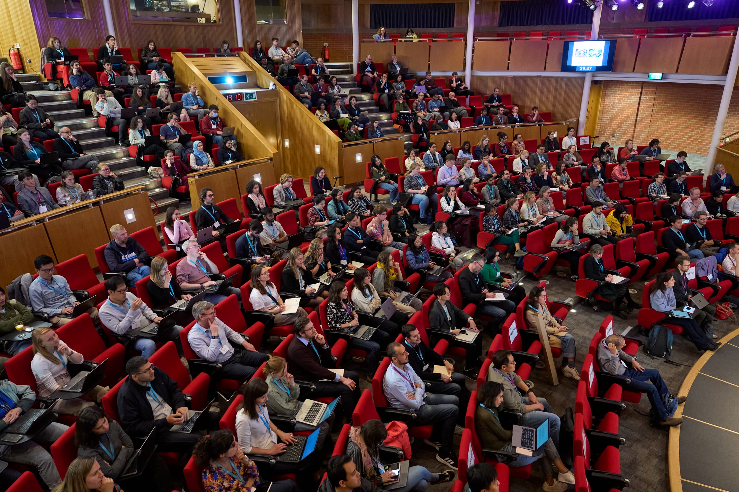 Conference delegates seated in the auditorium of Hinxton Hall on the Wellcome Genome Campus, UK
