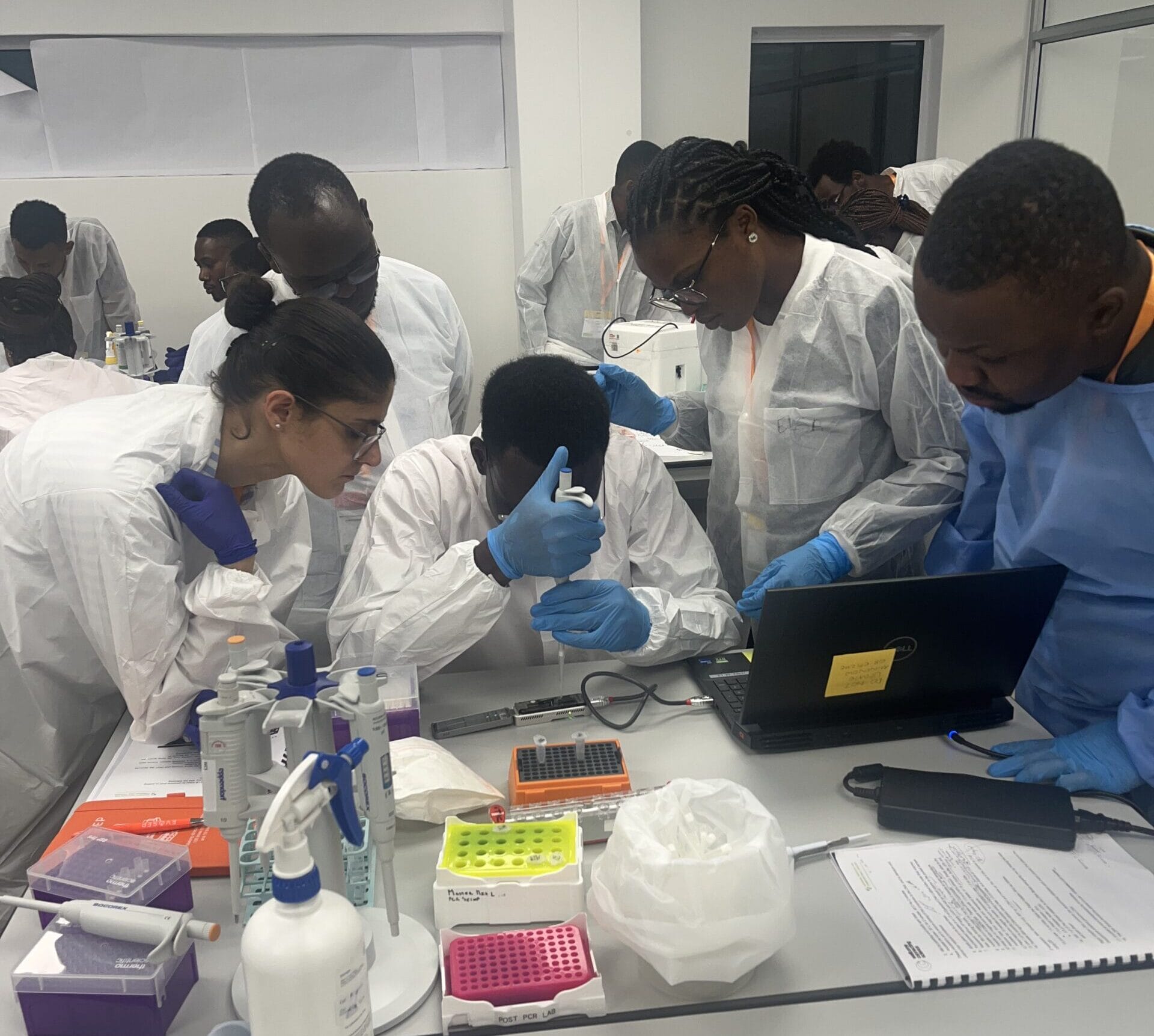 Course participants loading a MinION sequencer during a laboratory training exercise. 